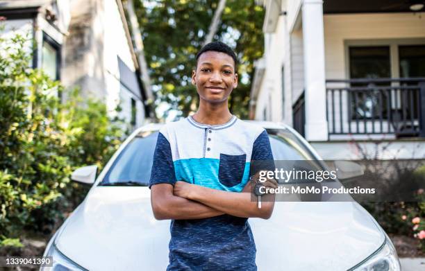 portrait of young man in front of his first car - car ownership fotografías e imágenes de stock