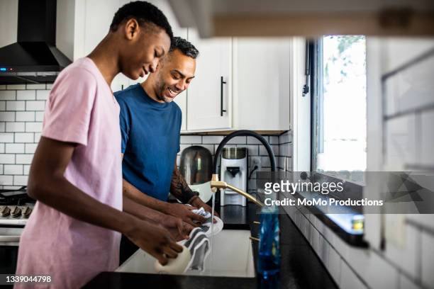 father and son washing dishes at home - dirty dishes ストックフォトと画像