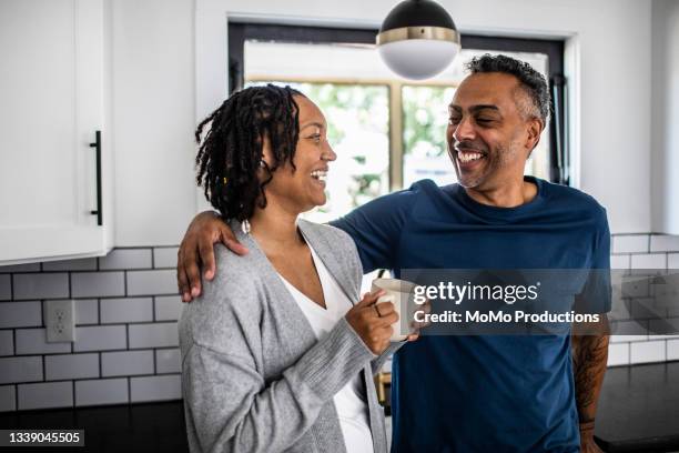 husband and wife hanging out in modern kitchen - navy shirt stock pictures, royalty-free photos & images