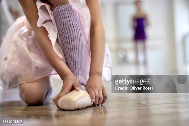 girl putting on ballet shoes in a dance studio - girls shoes bildbanksfoton och bilder