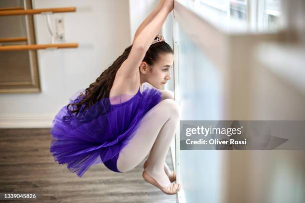 girl wearing a tutu looking out of window - girl side view stock-fotos und bilder