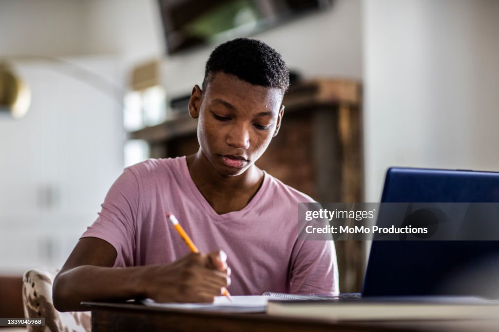 Teenage boy doing schoolwork at home