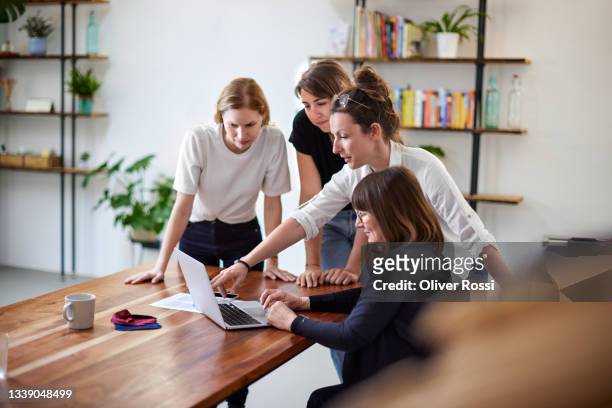 female business team with laptop having a meeting in office - weibliche führungskraft stock-fotos und bilder