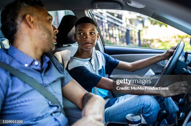 father teaching teenage son to drive - father and son discussion stock-fotos und bilder