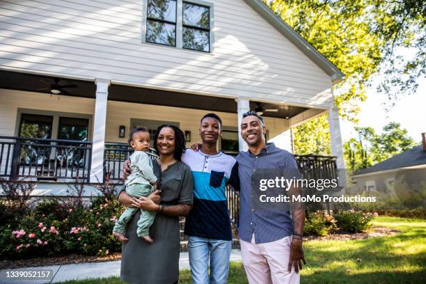 portrait of family in front of home - family of four in front of house stock pictures, royalty-free photos & images