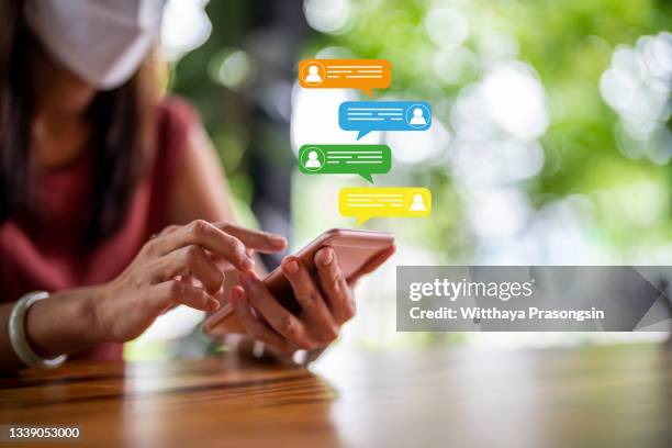 women's hand typing on mobile smartphone - customer support icon - fotografias e filmes do acervo