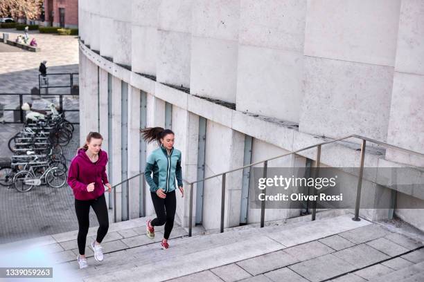 two young women running up stairs in the city - 2 steps stock-fotos und bilder