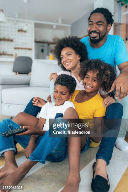 family watching television - family watching tv together stock pictures, royalty-free photos & images
