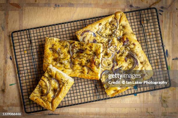 littlebourne, kent, england, uk. 13 august 2020. fresh foccacia bread cooling on a wire rack with a rosemary and red onion topping. - cutting red onion stock pictures, royalty-free photos & images