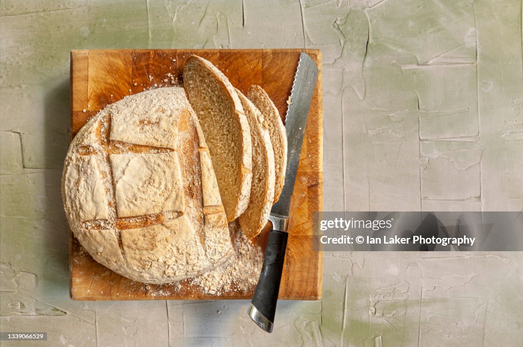Littlebourne, Kent, England, UK. 3 September 2021. Fresh bread sliced on a chopping board.
