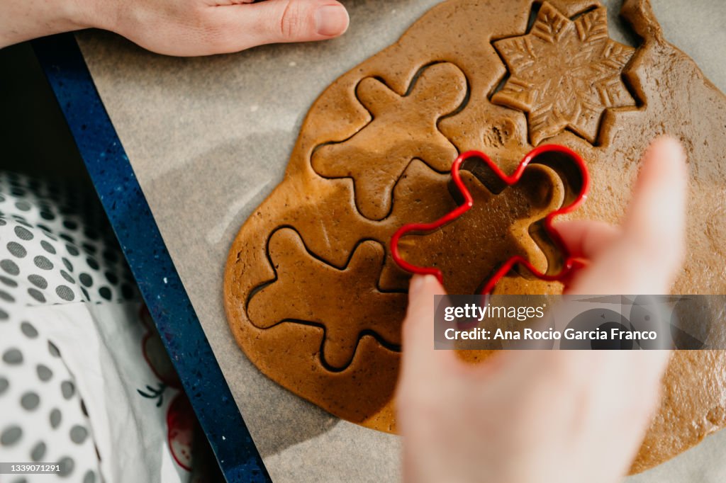 Close-up of woman hands using a gingerbread man cookie cutter