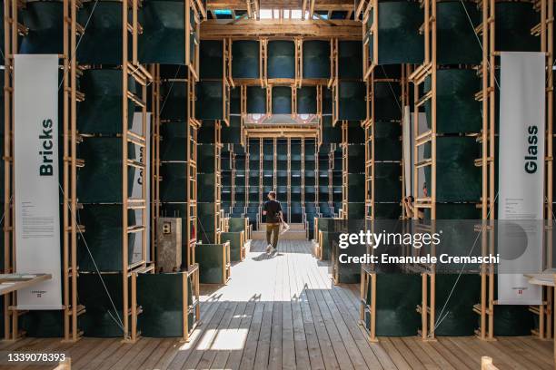 Man visits School of Hope, a pavilion by Danish company Lendager built of more than 500 chairs made of industrial waste plastic and temporarily...
