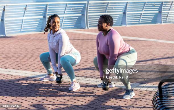 african-american women in city exercising, kettlebells - kettle bells stockfoto's en -beelden