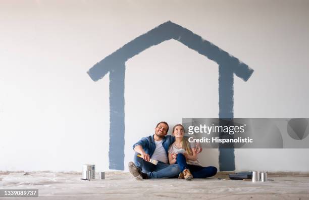 coppia che dipinge la propria casa e sogna ad occhi aperti come apparirà - sognare ad occhi aperti foto e immagini stock