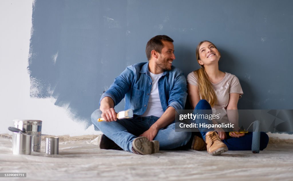 Loving couple having fun renovating their house and painting the walls