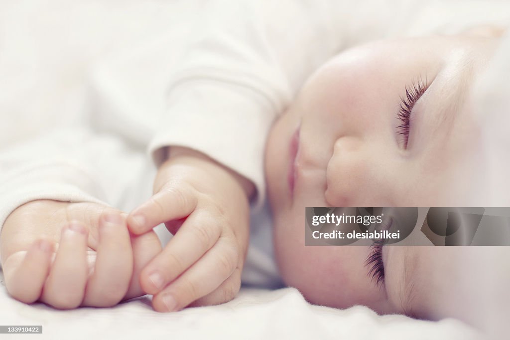 Close-up portrait of a beautiful sleeping baby on white