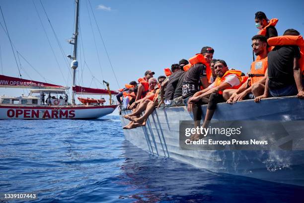 The boat 'Astral', of the NGO Open Arms, next to a boat where a total of 70 migrants are traveling, on September 8 in the Mediterranean Sea, in the...