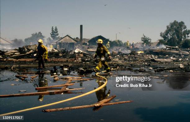 Los Angeles County firefighters and mutual aid agencies work within the debris field after a mid-air collision with Aeromexico Flight 498 and Piper...