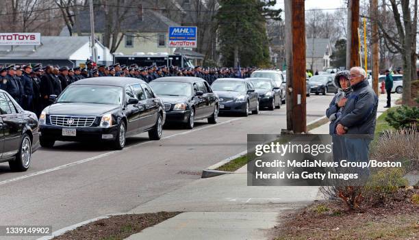 Couple watches as the procession leaves the church after the funeral for Boston Police officer Dennis Simmonds at First Baptist Church in Randolph....