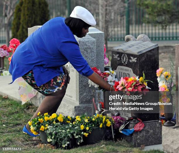 Ursula Ward, mother of Odin Lloyd, places her hand on her son's grave at Oak Lawn Cemetery in Boston on Wednesday, April 15, 2015. Former New England...