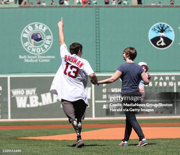 Jeff Bauman with his wife Erin Bauman and child Nora Gail Bauman walk out to the mound for the ceremonial first pitch before the Red Sox vs....
