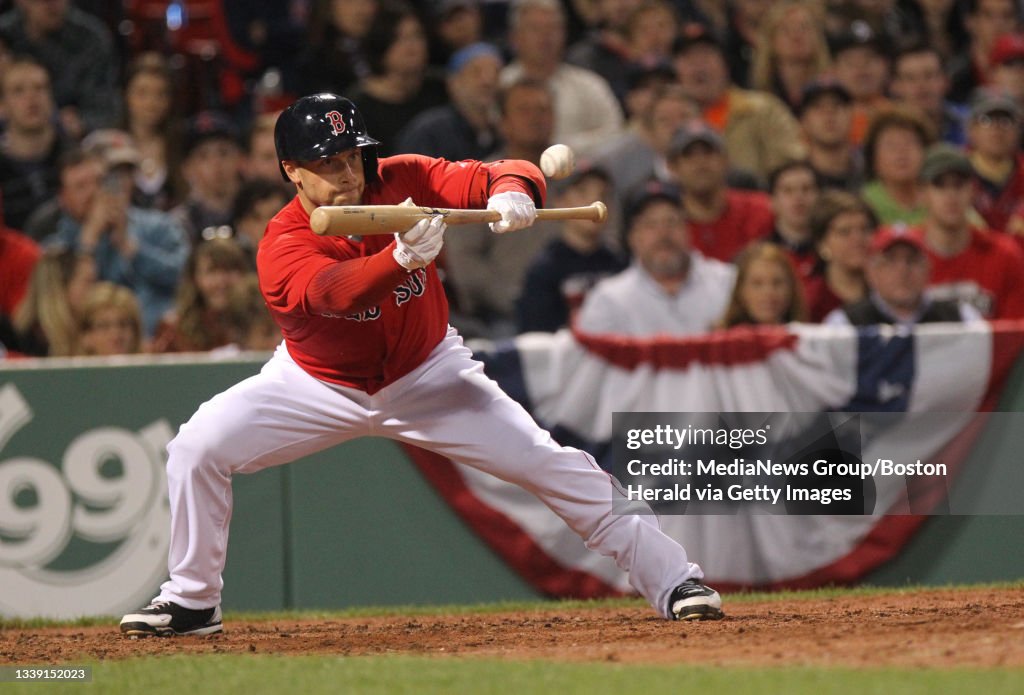 (Boston, MA, 04/17/15) Daniel Nava bunts in the ninth inning advancing Mike Napoli to second base during the Red Sox vs. Orioles game at Fenway Park. Friday, April 17, 2015. Staff photo by John Wilcox.