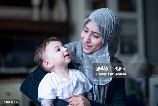 muslim mother and her toddler son - arab home stock pictures, royalty-free photos & images