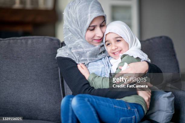 muslim mother and daughter snuggling together - afghani stock pictures, royalty-free photos & images