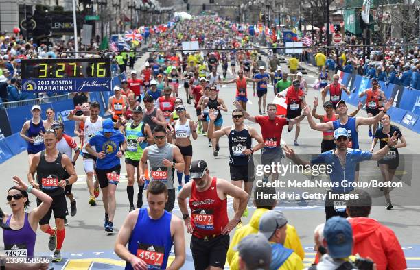 Runners cross the finish line during the 121st Boston Marathon in Boston on Monday, April 17, 2017. Staff photo by Christopher Evans