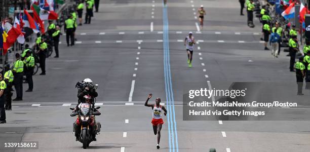 Men's winner Geoffrey Kirui of Kenya reacts as he approaches the finish line of the Boston Marathon on Monday, April 17, 2017. American Galen Rupp is...