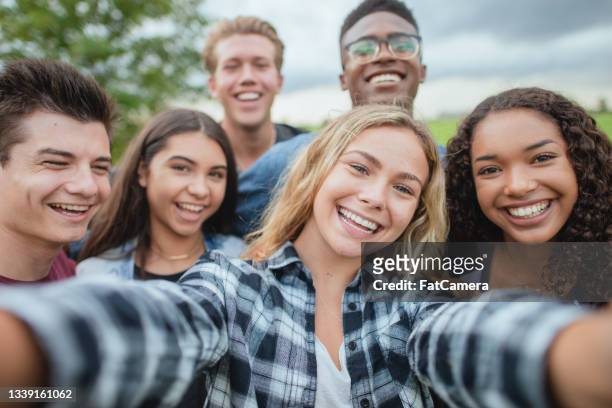 multiracial group of teenagers taking a selfie - boy girl stock pictures, royalty-free photos & images