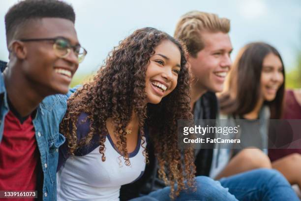 des adolescents divers et heureux qui traînent ensemble à l’extérieur - high school student photos et images de collection