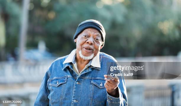 senior african-american man at park, talking to camera - man talking to camera stock pictures, royalty-free photos & images