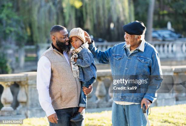 three generation african-american family walking in park - old person with walking stick outside standing stock pictures, royalty-free photos & images