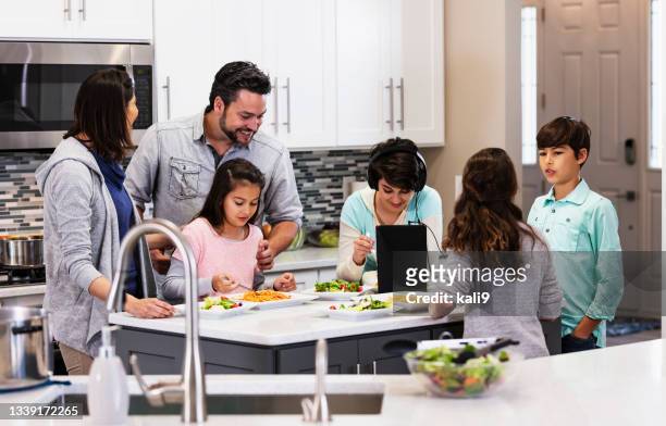 multiracial family with four children eating in kitchen - fyrbarnsfamilj bildbanksfoton och bilder