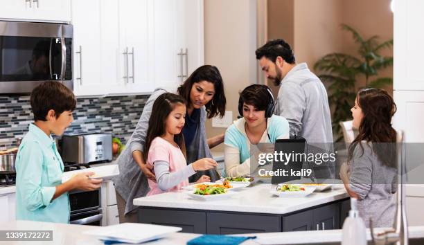 multiracial family with four children eating in kitchen - big family dinner stock pictures, royalty-free photos & images