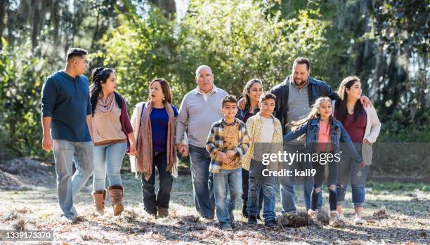 large multi-generation hispanic family walking at park - groepsfoto 6 personen stockfoto's en -beelden