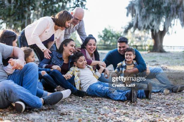 mehrgenerationen-hispanische familie im park, sitzen auf dem boden - tante stock-fotos und bilder