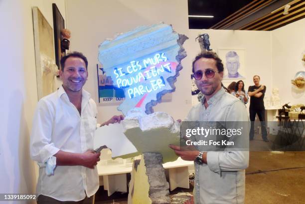Karim Berchiche and Luc Berchiche of La Fratrie pose with their work during Art Paris exhibition preview at Grand Palais Ephemere on September 08,...