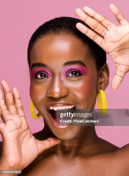 excited young african woman with mouth open frames face with hands - beautiful woman and eyeshadow stock pictures, royalty-free photos & images