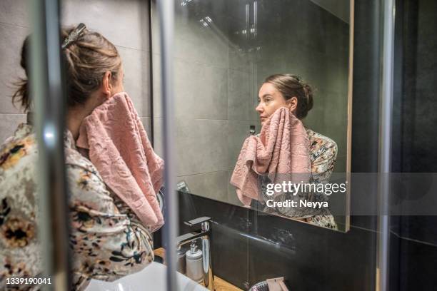 woman in silky bathrobe during evening routine in the bathroom - nighttime routine stock pictures, royalty-free photos & images