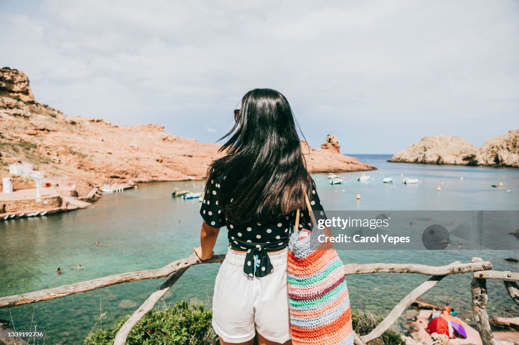 Beautiful latina standing in a balcony in Cala Morell,Minorca,Balearic islands; Spain