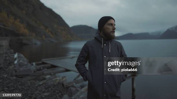 bearded fisherman portrait: with raincoat by a fjord at night - bergen norway stock pictures, royalty-free photos & images