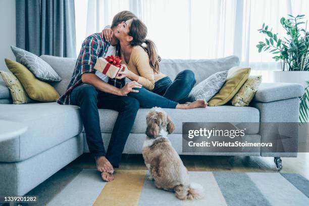 cheerful young woman receiving a gift from her boyfriend. - grant bildbanksfoton och bilder