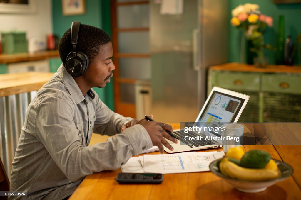 African man having a virtual meeting with his financial consultant from his own home