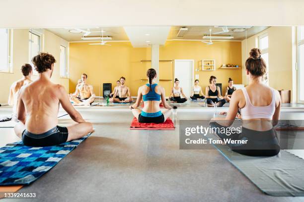 hot yoga class sitting on blankets - bikram yoga stock pictures, royalty-free photos & images