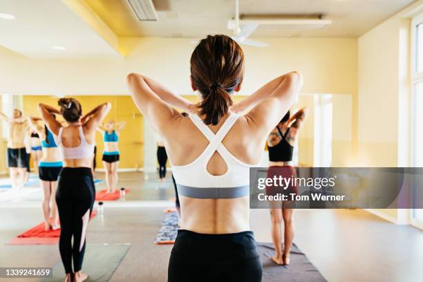 women posing in front of mirror doing hot yoga - sportbeha stockfoto's en -beelden