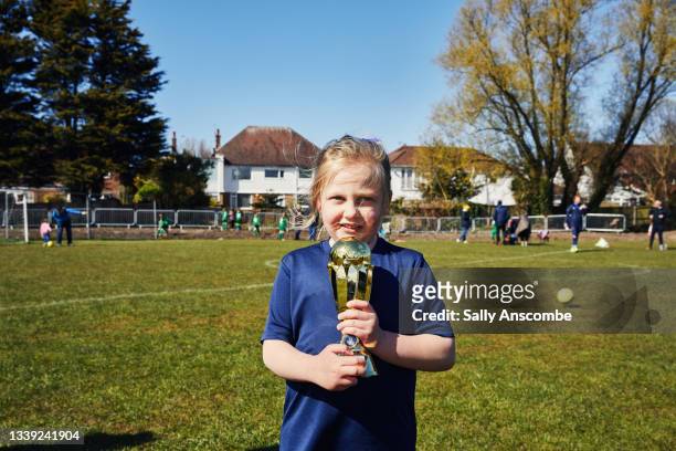 child holding a trophy after a football match - calcio di squadra foto e immagini stock