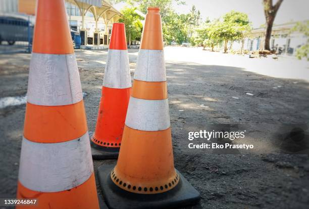 traffic cone for broken road divider - traffic cone stock-fotos und bilder