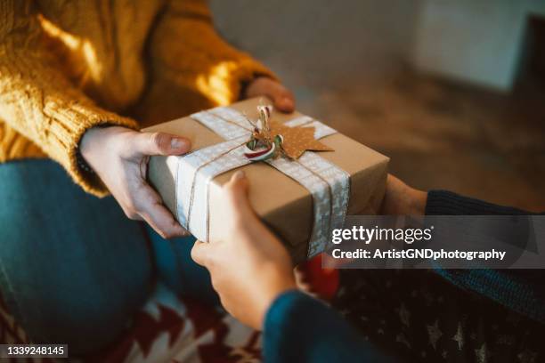 mani che danno il regalo di natale in primo piano - christmas couple foto e immagini stock